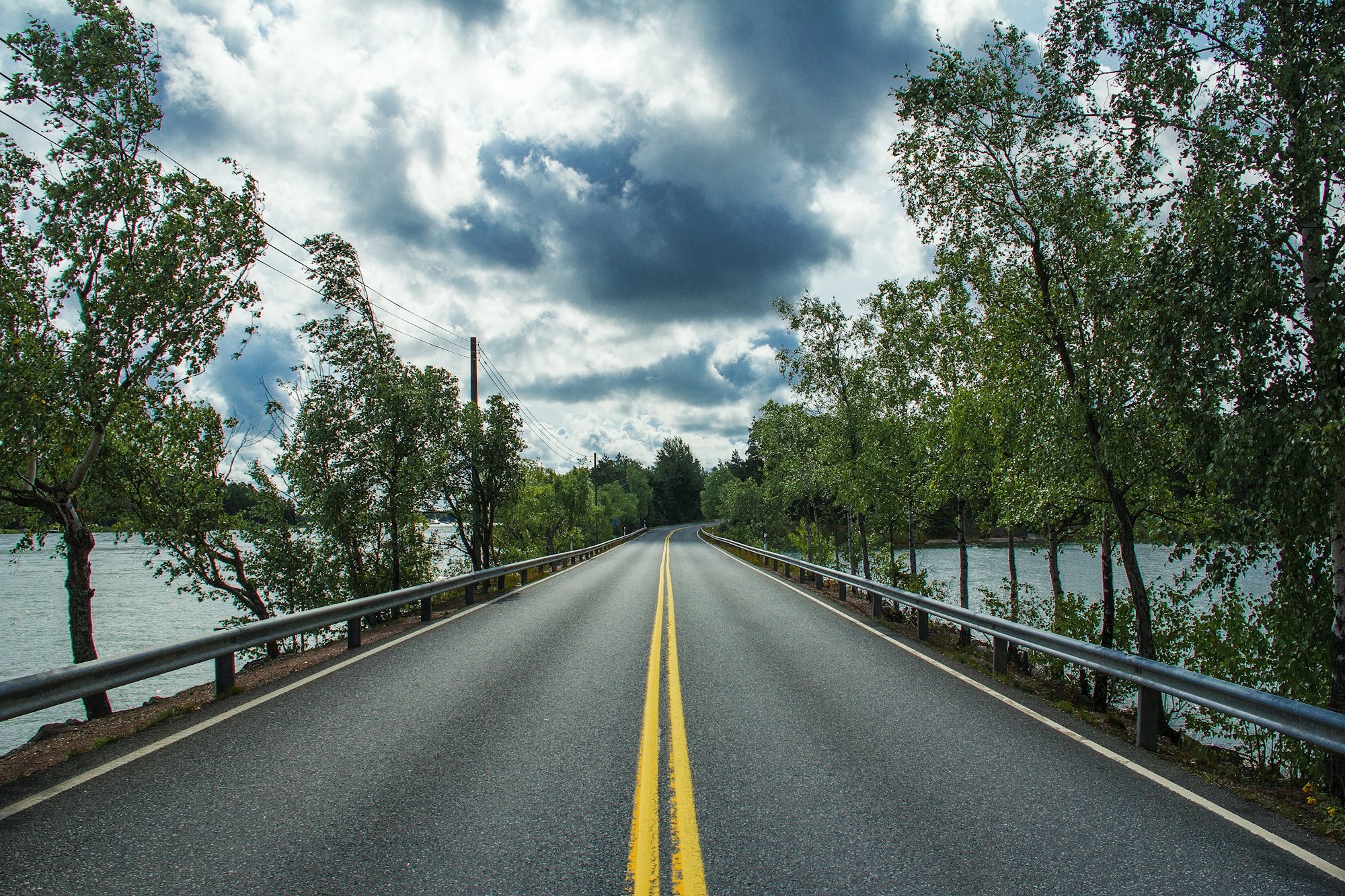 Open two-lane highway with a bold centre line running toward the mountains in British Columbia